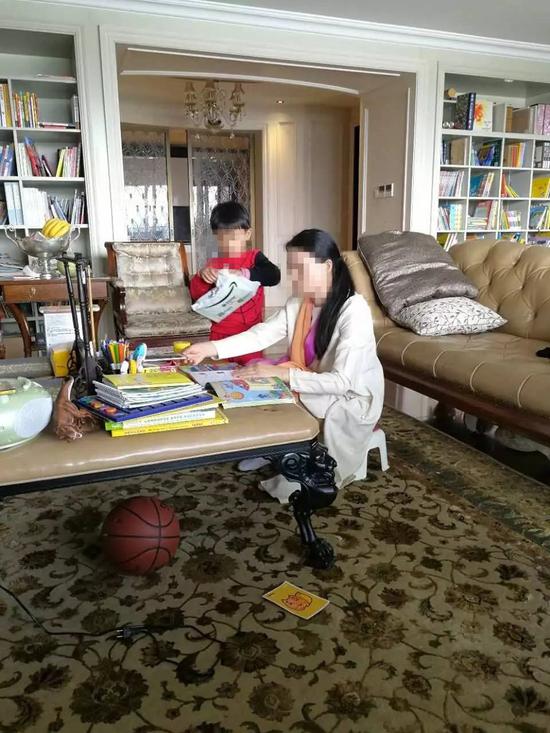 朱小貞和小兒子在客廳里，背后書架為起火點(diǎn)。（受訪者供圖）